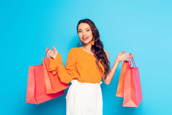 Happy Elegant Girl Holding Shopping Bags Smiling Camera Blue Background — Stock Photo, Image