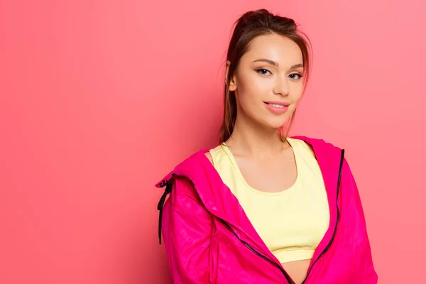 Atraente Sportswoman Confiante Rosa Windbreaker Sorrindo Para Câmera Fundo Rosa — Fotografia de Stock