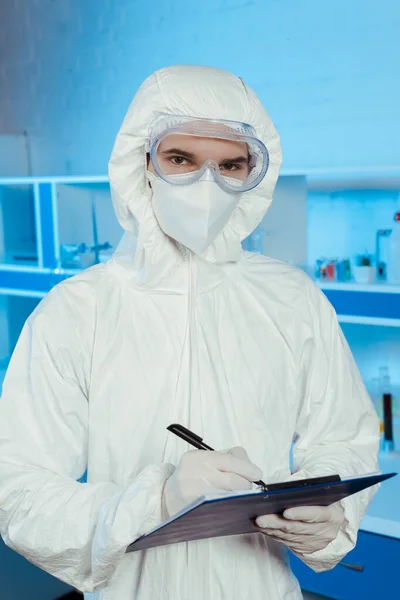 Cientista Terno Hazmat Óculos Segurando Prancheta Caneta — Fotografia de Stock