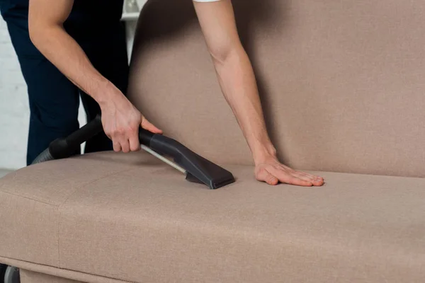 Visão Cortada Homem Limpando Sofá Moderno Com Aspirador — Fotografia de Stock