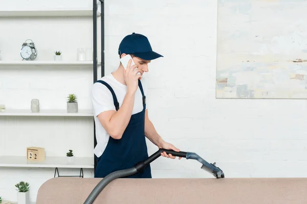 Cleaner Cap Overalls Cleaning Sofa Vacuum Cleaner Talking Smartphone — Stock Photo, Image