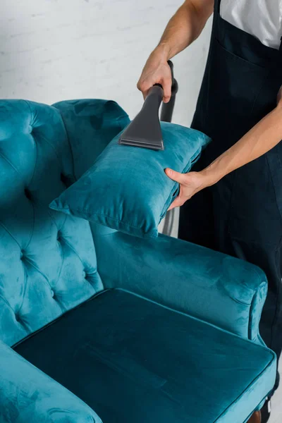 用真空吸尘器在现代扶手椅上清洗枕头的剪影 — 图库照片