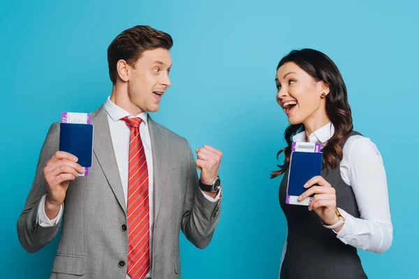Dwóch Szczęśliwych Biznesmenów Patrzących Siebie Trzymając Paszporty Bilety Lotnicze Niebieskim — Zdjęcie stockowe