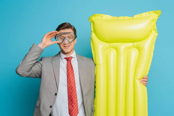 Smiling Businessman Holding Inflatable Mattress Touching Diving Mask Blue Background — Stock Photo, Image
