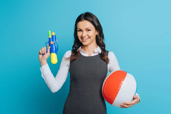 Glückliche Geschäftsfrau Mit Wasserpistole Und Aufblasbarem Ball Auf Blauem Hintergrund — Stockfoto