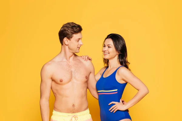 Cheerful Woman Swimsuit Touching Shoulder Handsome Shirtless Boyfriend Yellow Background — Stock Photo, Image