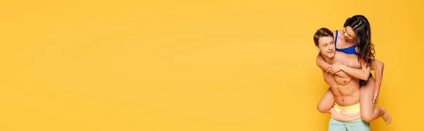Панорамный Снимок Красивого Мужчины Рубашки Сидящего Спине Девушки Изолированной Желтом — стоковое фото