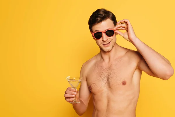 Shirtless Man Touching Sunglasses While Holding Glass Cocktail Yellow Background — Stock Photo, Image