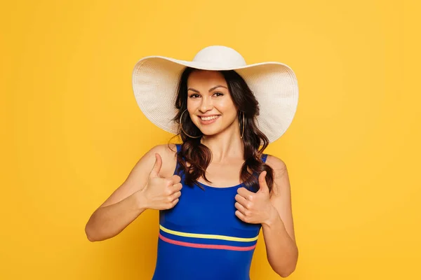 Vrolijke Vrouw Zonnehoed Badpak Tonen Duimen Omhoog Geïsoleerd Geel — Stockfoto