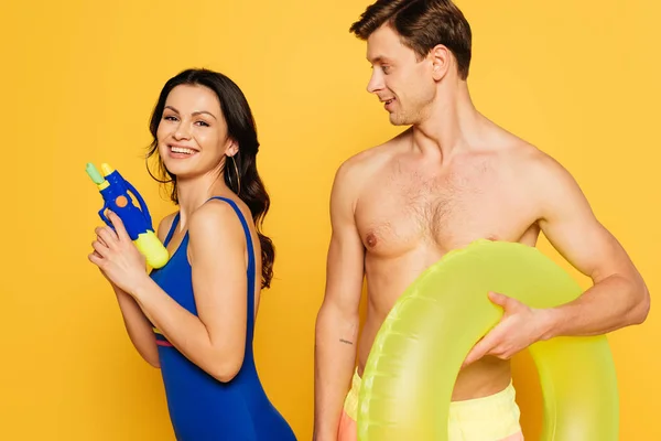 Alegre Mujer Sosteniendo Pistola Agua Cerca Hombre Sin Camisa Con — Foto de Stock