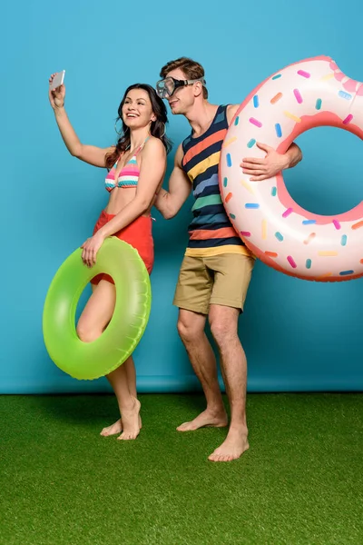 Cheerful Couple Inflatable Rings Taking Selfie Smartphone Blue Background — Stock Photo, Image