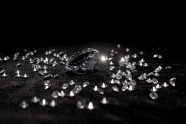 Selective focus of gemstones on black velvet isolated on black  clipart