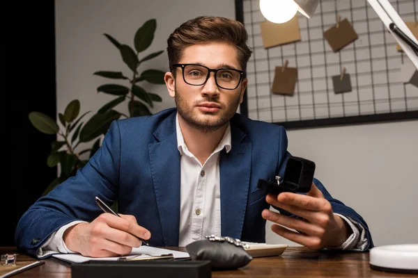 Evaluador Joyas Mirando Cámara Mientras Sostiene Caja Con Anillo Escritura — Foto de Stock