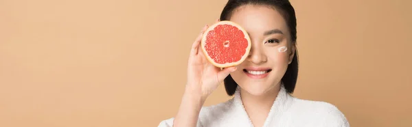 Smilende Smuk Asiatisk Kvinde Badekåbe Med Ansigtscreme Kind Grapefrugt Halvdelen - Stock-foto