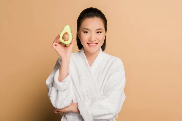 Felice Bella Donna Asiatica Accappatoio Con Avocado Metà Sfondo Beige — Foto Stock