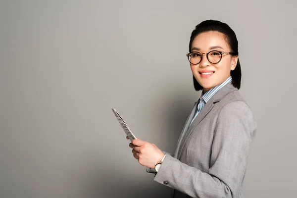 Side View Smiling Young Businesswoman Eyeglasses Holding Newspaper Grey Background — Stock Photo, Image