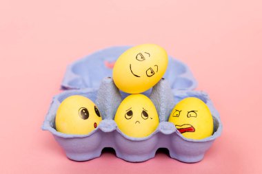 Paskalya yumurtalarının seçici odak noktası pembe yumurta tepsisinde yüz ifadeleri. 
