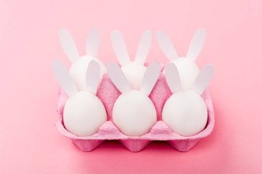 Süslü paskalya tavşanları pembe yumurta tepsisinde