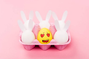 Süslü tavşanlar ve sarı yumurta. Pembe, paskalya konseptinde sevimli bir yüz ifadesi var.