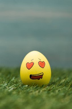 Easter egg with enamored facial expression on grass  clipart