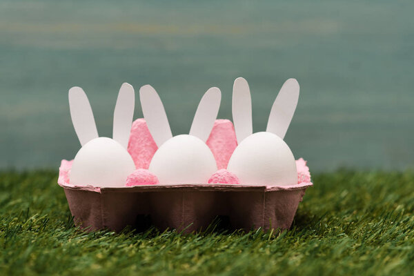 Decorative bunnies in pink egg tray, easter concept