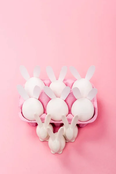 Vysoký Úhel Pohledu Dekorativní Velikonoční Králíky Vajíčkem Zásobník Růžovém Pozadí — Stock fotografie