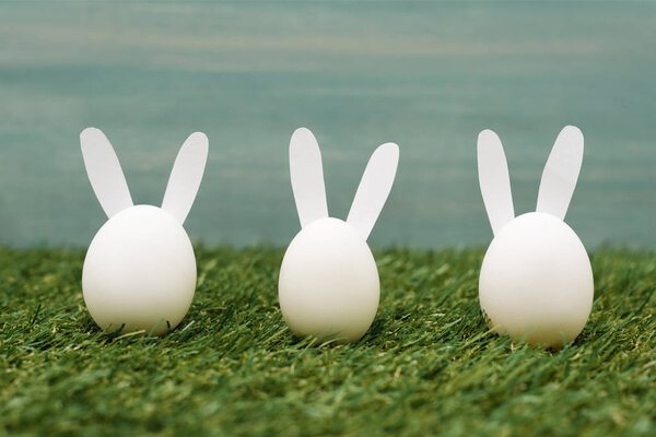 Decorative white bunnies on grass, easter concept