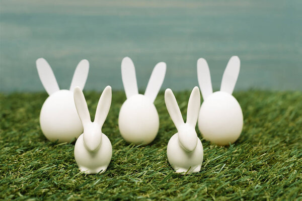 Decorative white easter bunnies on grass