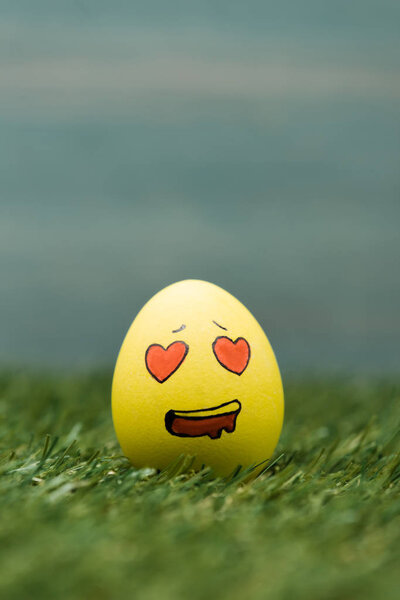 Easter egg with enamored facial expression on grass 