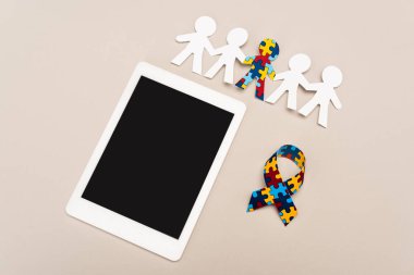 High angle view of awareness ribbon, digital tablet and special kid with autism among another on white clipart