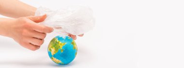 Cropped view of woman holding plastic bag above globe on white, global warming concept clipart