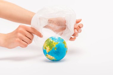 Partial view of woman holding plastic bag above globe on white, global warming concept clipart