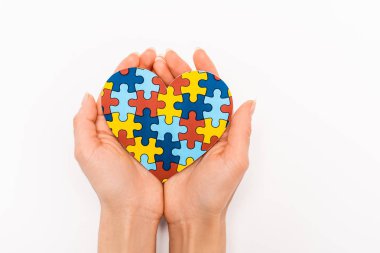 Cropped view of puzzle heart in female hands on white background, autism concept clipart