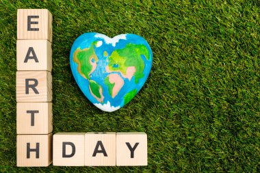 Küplerin en üst görüntüsü. Yeşil arka planda Dünya Günü harfleri ve küre. 