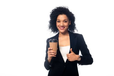 Afro-Amerikan 'ın tek kullanımlık kahve fincanının önünde gülümseyen ve baş parmağını beyazın üstünde gösteren.