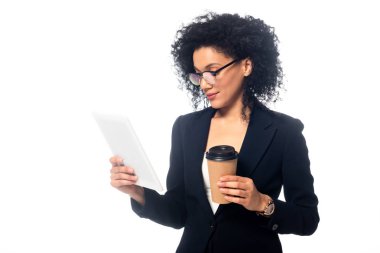 Afrikalı Amerikalı iş kadını dijital tablet üzerinde yoğunlaştı ve beyaz üzerine izole edilmiş tek kullanımlık kahve bardağını elinde tuttu.