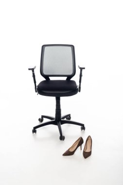 Siyah ofis sandalyesi ve beyaz arka planda ayakkabılar.