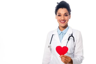 Steteskopu olan Afrikalı Amerikalı doktor, beyaza izole edilmiş dekoratif kırmızı kalp gösteriyor.