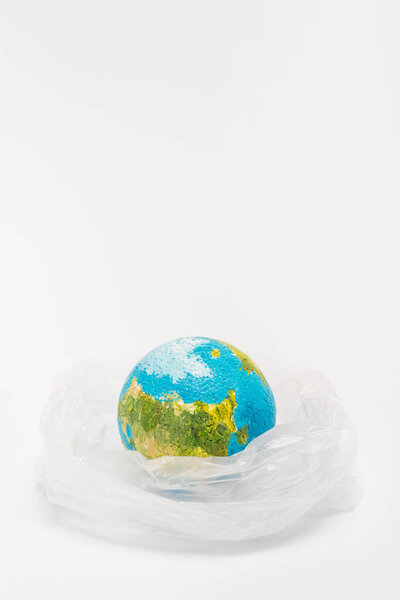 Глобус внутри пластикового пакета на белом фоне, концепция глобального потепления
