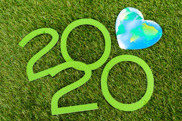 Top view of 2020 digits and globe on green background, earth day concept