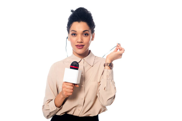 Front view of african american journalist with microphone and headphones looking at camera isolated on white