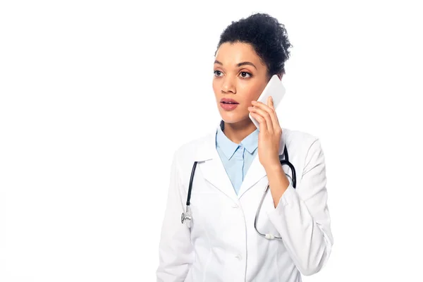 ショックを受けたアフリカ系アメリカ人医師のフロントビューとともに聴診器は白い上に隔離されたスマートフォンで話す — ストック写真