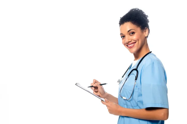 Side View African American Nurse Stethoscope Writing Clipboard Smiling Isolated — Stock Photo, Image