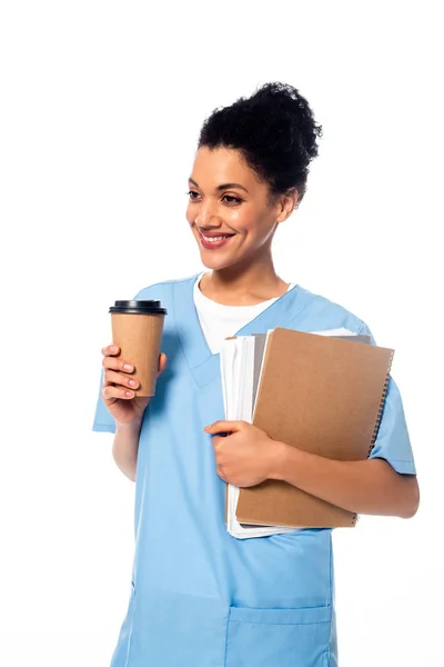 幸せと肯定的なアフリカ系アメリカ人看護師紙と白に隔離されたコーヒーの使い捨てカップと — ストック写真
