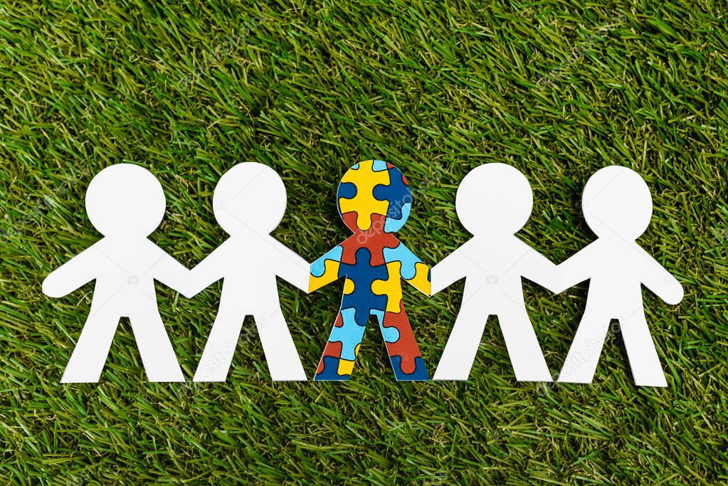 Top view of special kid with autism among another on green background