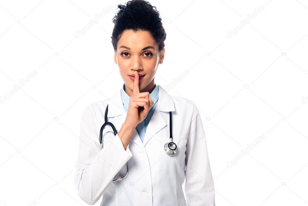 Front view of african american doctor with stethoscope showing quiet and looking at camera isolated on white