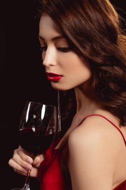 Kırmızı dudakları olan güzel bir kadın. Elinde siyah şarap kadehi var.