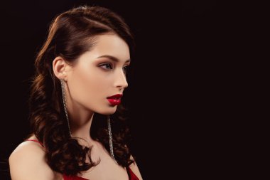 Kırmızı dudakları olan zarif bir kız, tek başına siyahlara bakıyor.