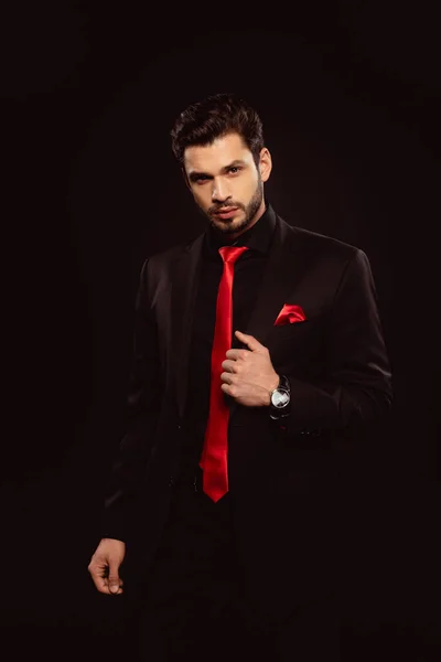 Elegante Hombre Traje Negro Corbata Roja Mirando Cámara Aislada Negro — Foto de Stock
