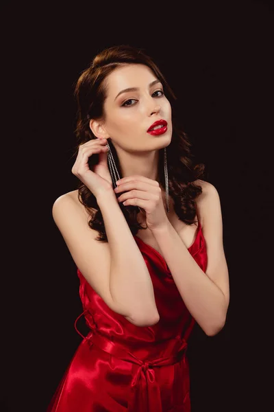 Beautiful Woman Red Dress Touching Earring Looking Camera Isolated Black — Stock Photo, Image